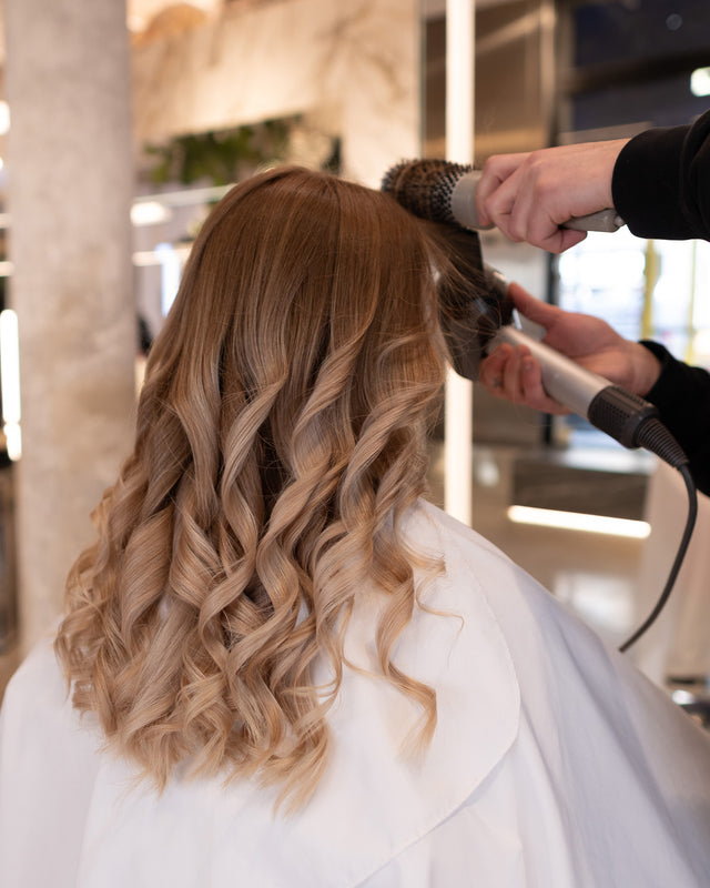 A woman’s hair styled into soft waves at ELIJAH